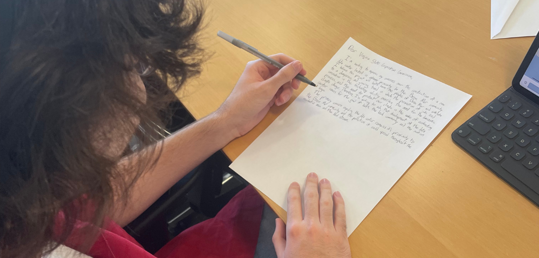 A Fordham Law student handwrites a letter to elected officials